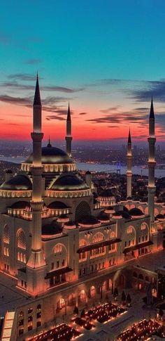 an aerial view of a large building with many spires and lights on it's sides