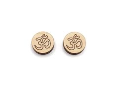 two small wooden earrings with the symbol om