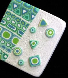 a ceramic tile with green and blue designs on it