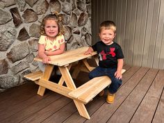 two young children sitting at a picnic table