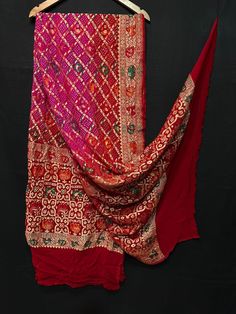 A beautifully Handwoven PATOLA Pure BANARASI GEORGETTE MEENAKARI BANDHANI DUPATTA with all over ZARI weave making it a Royal one Georgette is a light-weight, crinkled and sheer fabric, displaying an overall bouncy look. A strong absorbent, Georgette is easy to dye and has dull-rough texture. Pure Georgette is woven out of Silk yarns A Shikargah work is usually work of zari shaped as forest or animals generally in a hunting posture. The borders and the motifs are beautifully spaced out with proficient craftsmanship which turns the beholder "Sui Generis" Banarasi is globally acclaimed for its rich use of zari (brocade)) and beautiful bandhani dyes.  Bandhani, also known as Bandhej; is a type of TIE DYE textile which is adorned by plucking the cloth into many bindings, that form a design. ... Festive Bandhani Print Slub Silk Dupatta, Semi-stitched Art Silk Bandhani Print Dupatta, Festival Bandhani Print Semi-stitched Dupatta, Luxury Bandhani Print Dupatta, Multicolor Bandhani Print Dupatta Semi-stitched, Indian Shawl, Bandhej Suits, Bandhej Dupatta, Types Of Ties