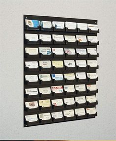 a black and white wall mounted display with many different cards on it's sides