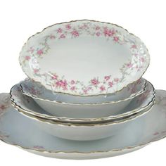 three white dishes with pink flowers on them