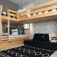 a bedroom with bunk beds and a futon sofa in the corner, along with a rug on the floor