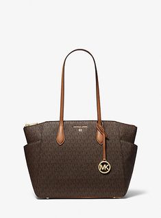 Our Marilyn carryall is the ultimate tote bag for everyday wear. The brand’s iconic “MK” initials leave a memorable mark, while the structured silhouette unzips to reveal a spacious interior with dedicated pockets for your daily essentials. We love how the slender leather straps easily slip over your shoulder to ensure on-the-go ease. Tote Bag Michael Kors, Affliction Clothing, Logo Tote Bag, Bag Michael Kors, Media Logo, Bags Logo, Medium Tote, Designer Gifts, Daily Essentials