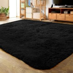 a living room with a large black rug on the floor