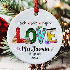 a personalized ornament hanging from a christmas tree with the word love on it