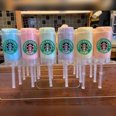 five starbucks cups are lined up on a counter