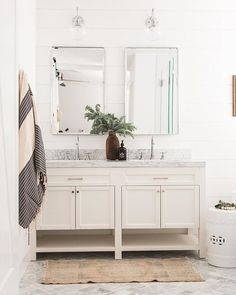 a white bathroom with two sinks and a mirror above the sink is featured in an instagram