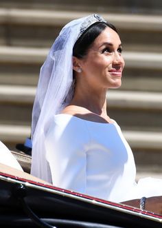 the bride is smiling as she rides in her carriage