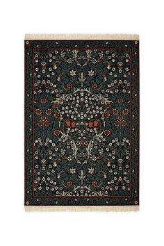 a black rug with red and green flowers on the bottom, in front of a white background