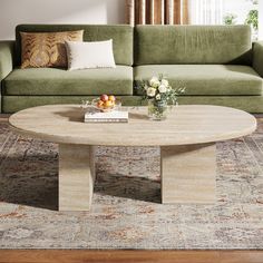 a living room with a green couch, coffee table and rug on the floor in front of it