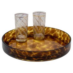 two glasses sitting on top of a glass tray