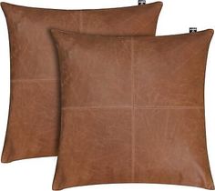 two brown leather pillows sitting on top of each other