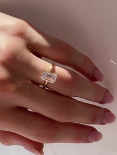 a woman's hand with a diamond ring on it