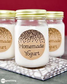 three jars filled with homemade yogurt sitting on top of a cloth covered table