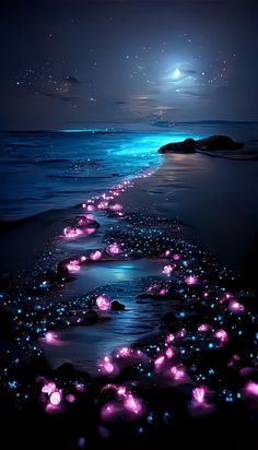 the night sky is lit up with glowing stars and lights on the water's edge