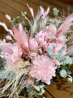 a bouquet of pink flowers sitting on top of a wooden table