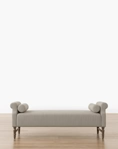 a gray couch sitting on top of a wooden floor next to a white wall and hardwood floors