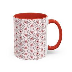 a red and white coffee mug with an intricate design on the outside, in front of a white background