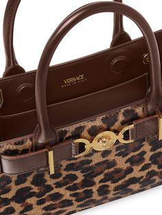 "Find VERSACE Medusa 95 Tote Bag on Editorialist. The Versace Medusa 95 tote bag is crafted in Italy from dyed calf hair with a leopard print. It features two top handles, a magnetic closure, and a gold tone buckle detail. The bag is lined in leather and measures approximately 9.1\"W x 5.5\"H x 3.15\"D. It is made in Italy and features a fur origin from New Zealand." Designer Leopard Print Travel Bag, Leopard Print Leather Shoulder Bag With Top Handle, Designer Rectangular Bag In Leopard Print, Top Handle Bags In Leopard Print, Designer Leather Bags In Leopard Print, Leopard Print Leather Bag With Gold-tone Hardware, Leopard Print Leather Top Handle Bag, Designer Leopard Print Bag For Everyday Use, Leopard Print Top Handle Shoulder Bag