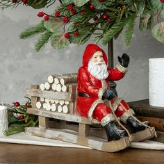 a santa clause figurine sitting on top of a wooden sleigh