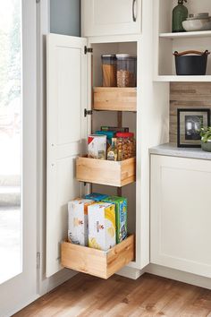 an open pantry with wooden drawers and white cabinets