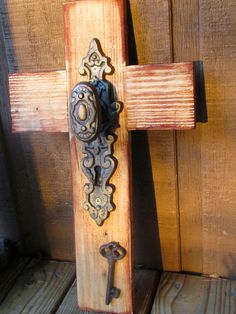 an old wooden cross with a key on it