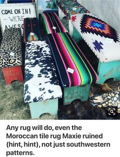 several different colored benches sitting next to each other on the ground in front of a tent