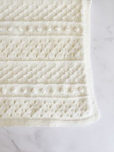 a white crocheted blanket sitting on top of a table