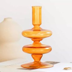 an orange vase sitting on top of a table