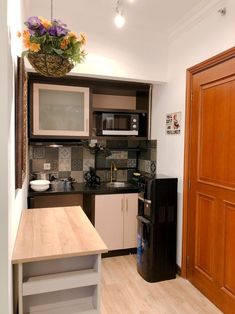 a kitchen with wooden floors and black appliances