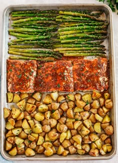 salmon, potatoes and asparagus in a baking pan with sauce on the side