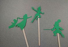 three green cupcake toppers with tinker fairy on them are sitting on a table