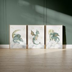 three dragon paintings sitting on top of a wooden floor