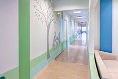 the hallway is decorated in pastel colors and has a tree painted on the wall