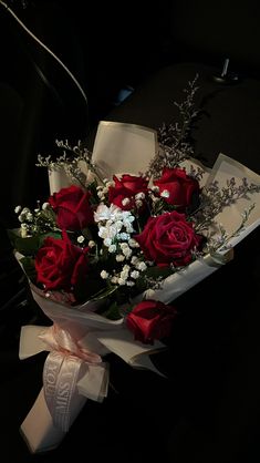 a bouquet of red roses and white baby's breath