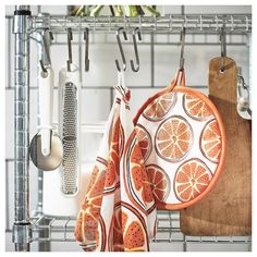 oranges and other kitchen accessories hanging on a rack