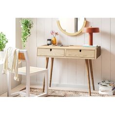 a wooden desk with two drawers and a mirror on the wall next to a chair