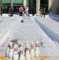 several bowling pins are lined up in the snow