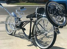 two bikes are parked next to each other on the sidewalk in front of a blue car