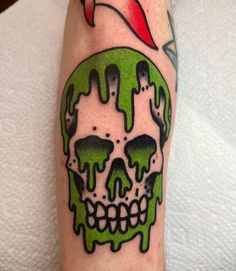 a skull with green paint on it's face is shown in this tattoo design