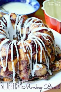 a blueberry monkey bread with icing on a plate