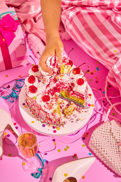 a child's hand reaching for a piece of birthday cake