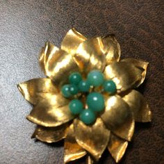 "Vintage Brooch, Vintage Costume Jewelry Flower in Gold Tone with Green Center Beads. Lovely and possibly from the 40's or 50's, this brooch or pin is in good condition, shiny and well taken care of. It measures 2.75\" long and nearly 2\" wide at the widest part of the flower petals. 16 flower petals are lovely gold brushed and 9 center green beads resemble jade. Nice shiny stem. New Recycled Kraft Cotton Filled Gift Box with Ribbon Included. Antiques and Vintage items are the most sustainable w Gift Box With Ribbon, Box With Ribbon, Jewelry Flower, Green Beads, Brooch Vintage, Vintage Brooch, Green Bead, Vintage Costume Jewelry, Vintage Costumes