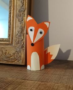 an orange and white paper fox next to a mirror