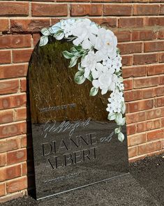 a memorial stone with flowers on it in front of a brick wall that reads, imagine diane albert