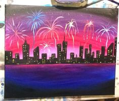 someone is painting a cityscape with fireworks in the sky