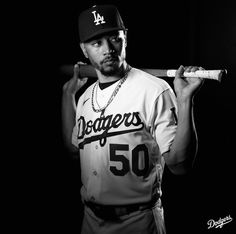 a black and white photo of a baseball player holding a bat