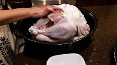 a person holding a turkey in a pot